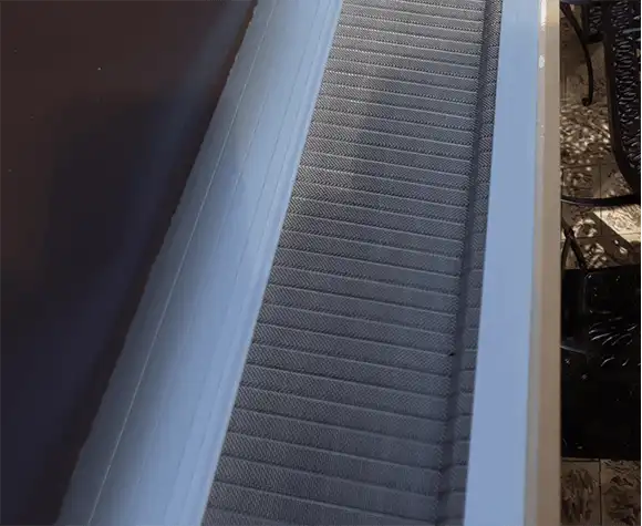 Close-up view of a clean air conditioning filter housed inside the unit, with some furniture visible in the background.