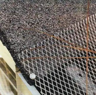 A metal mesh barrier is installed along a roof edge, with a possum visible underneath the mesh.